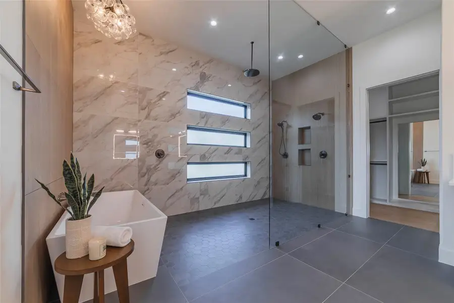 Bathroom with a walk in closet, a walk in shower, tile patterned floors, a soaking tub, and recessed lighting