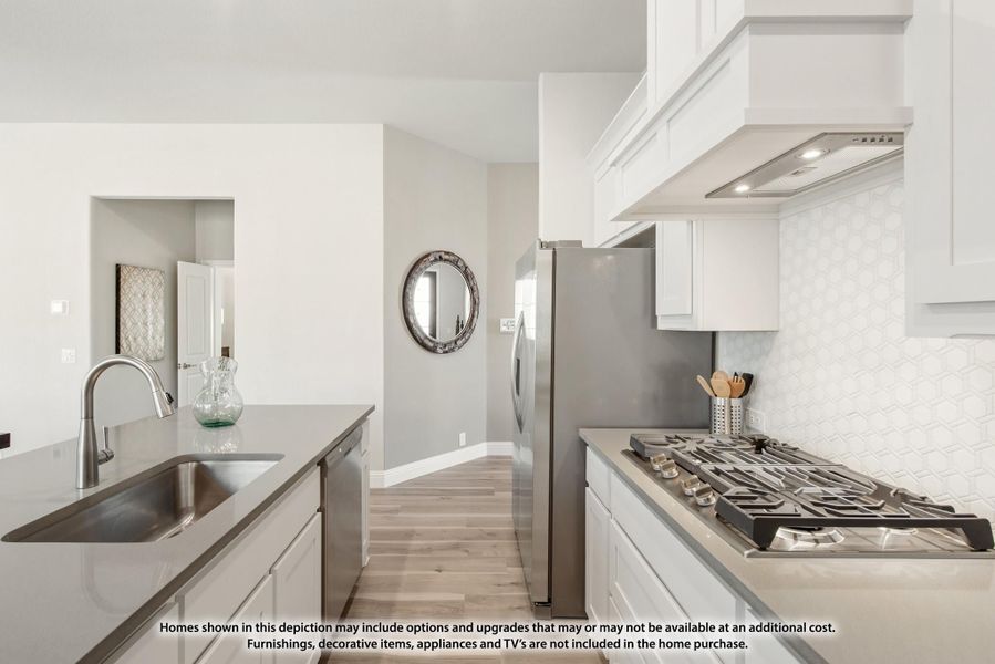 Kitchen with white cabinets, stainless steel appliances, gas cooktop, and white geometric tile backsplash Kitchen with white cabinets, stainless steel appliances, gas cooktop, and white geometric tile backsplash
