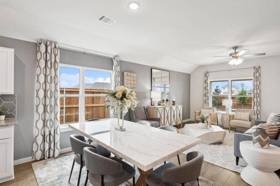 Dining space with plenty of natural light, wood finished floors, lofted ceiling, ceiling fan, and recessed lighting