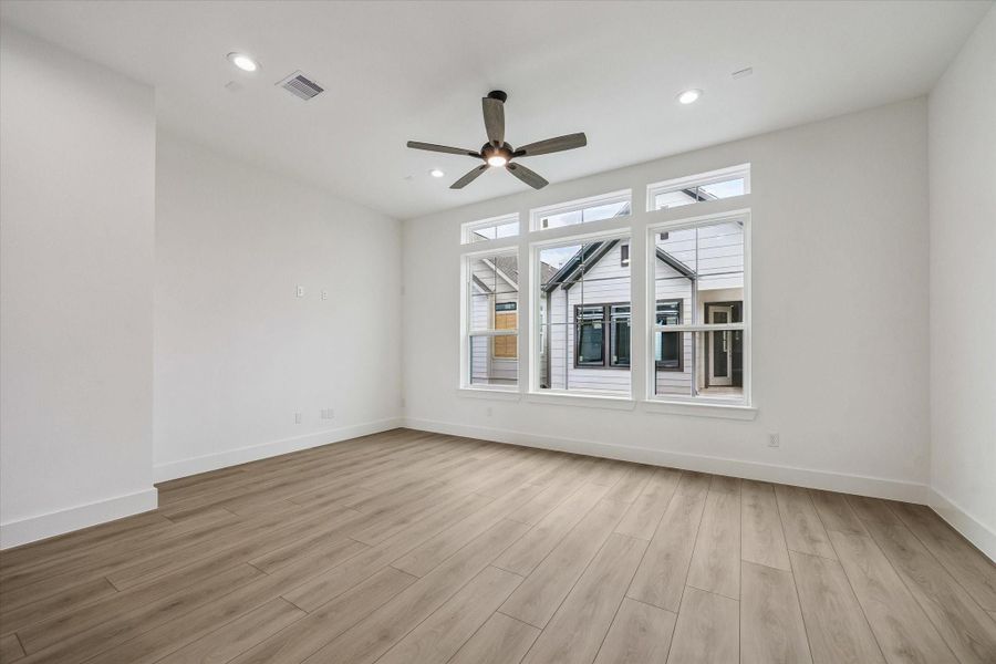 Large primary bedroom with multiple windows and comfortable proportions Large primary bedroom with multiple windows and comfortable proportions
