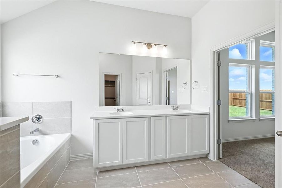 Bathroom with light tile patterned flooring, double vanity, and a bath Bathroom with light tile patterned flooring, double vanity, and a bath