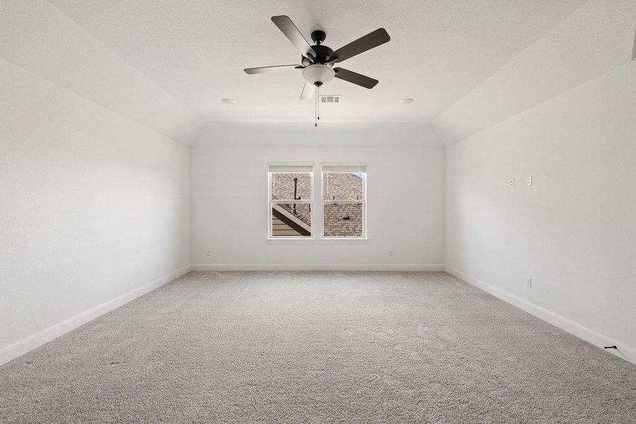 Empty room with carpet floors, a ceiling fan, and lofted ceiling Empty room with carpet floors, a ceiling fan, and lofted ceiling