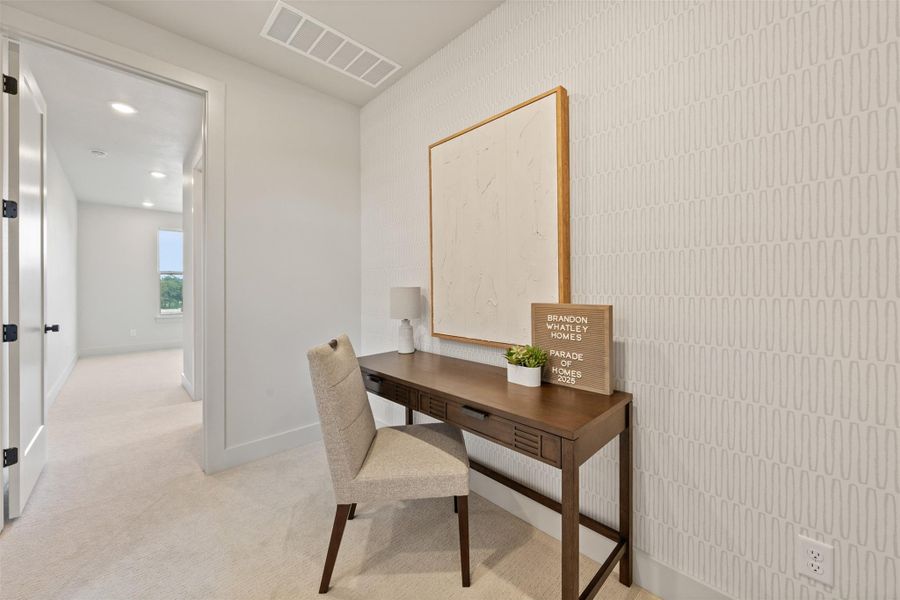 Office area with light colored carpet and recessed lighting