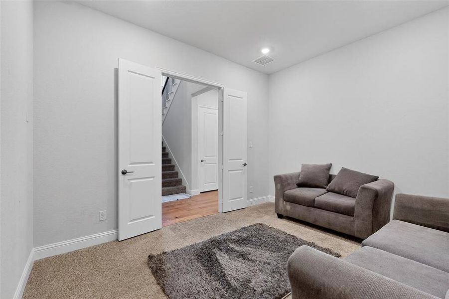 Living room featuring light colored carpet, stairway, and recessed lighting