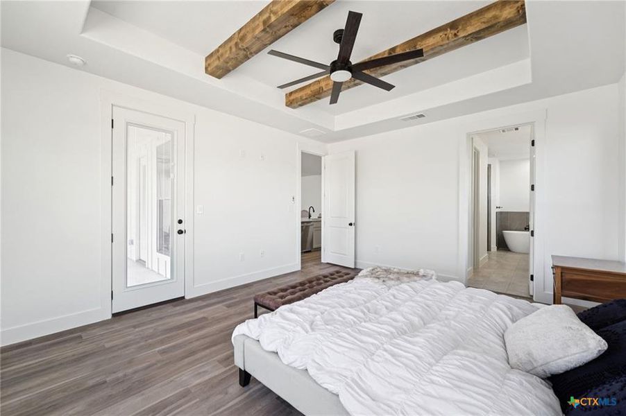 Exposed wood beams adorn the ceiling of this spacious bedroom, offering rustic elegance and direct access to a private bathroom. Exposed wood beams adorn the ceiling of this spacious bedroom, offering rustic elegance and direct access to a private bathroom.