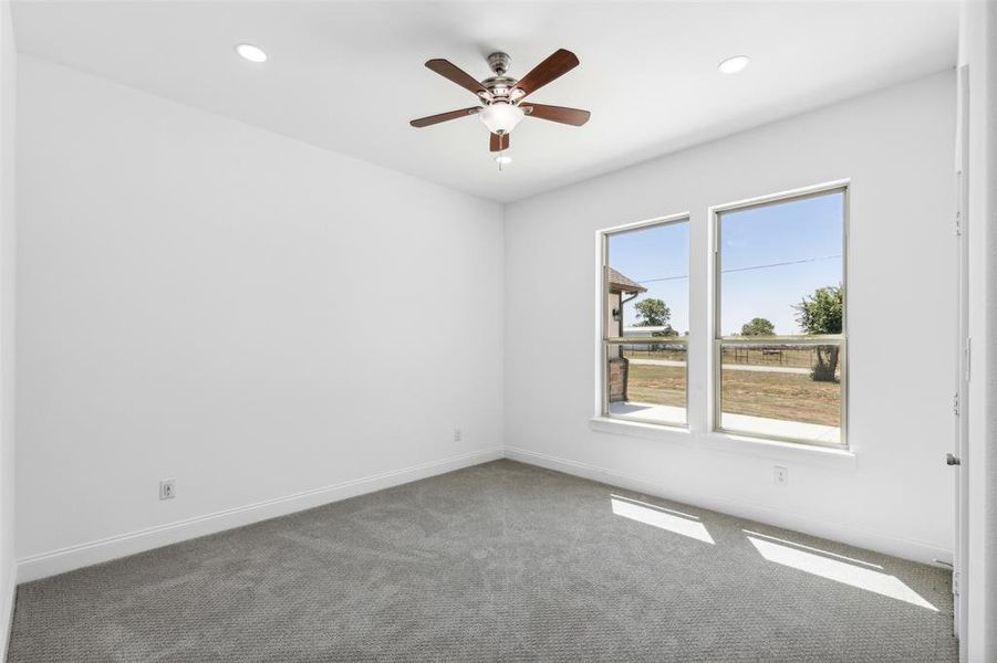 Carpeted empty room with ceiling fan