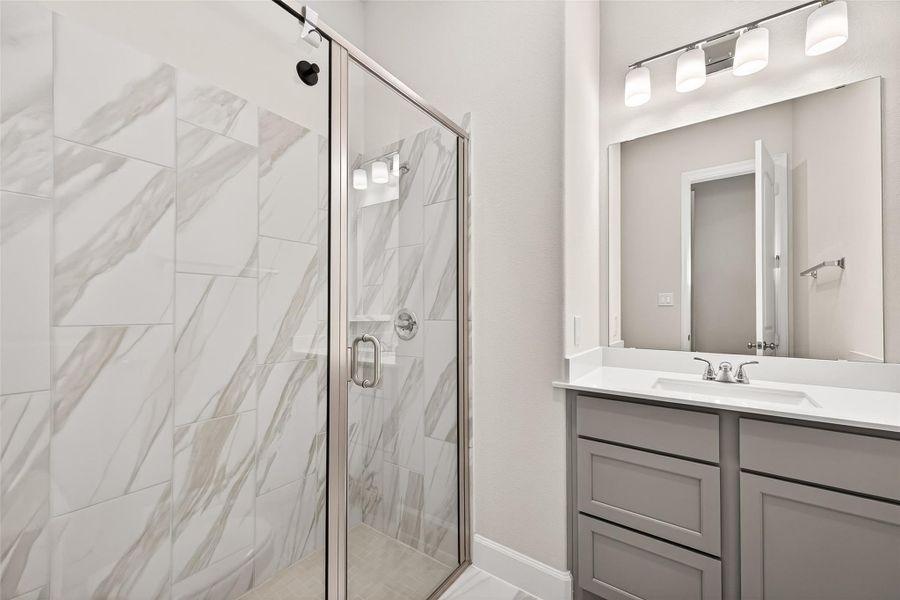 Secondary bathroom conveniently situated between the two secondary bedrooms, featuring a sleek stand-up shower that combines style and functionality for family members and guests Secondary bathroom conveniently situated between the two secondary bedrooms, featuring a sleek stand-up shower that combines style and functionality for family members and guests