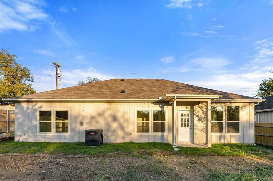 Rear view of property featuring roof with shingles