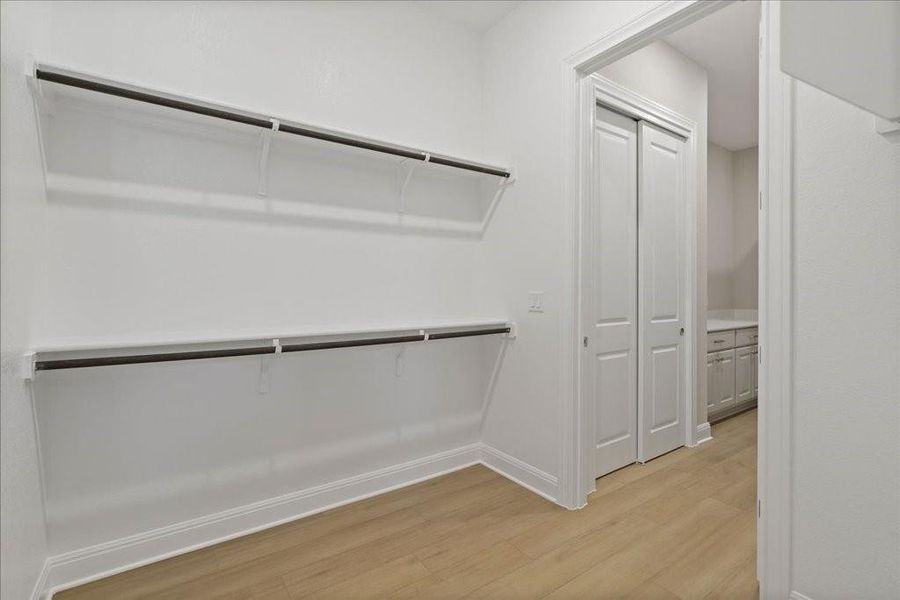 One of two walk-in closets in the owner's suite with direct access to a third, smaller closet and the laundry room.