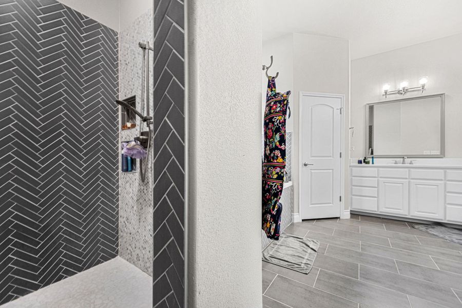Herringbone tiled shower and contemporary flooring create a modern bathroom retreat. Herringbone tiled shower and contemporary flooring create a modern bathroom retreat.