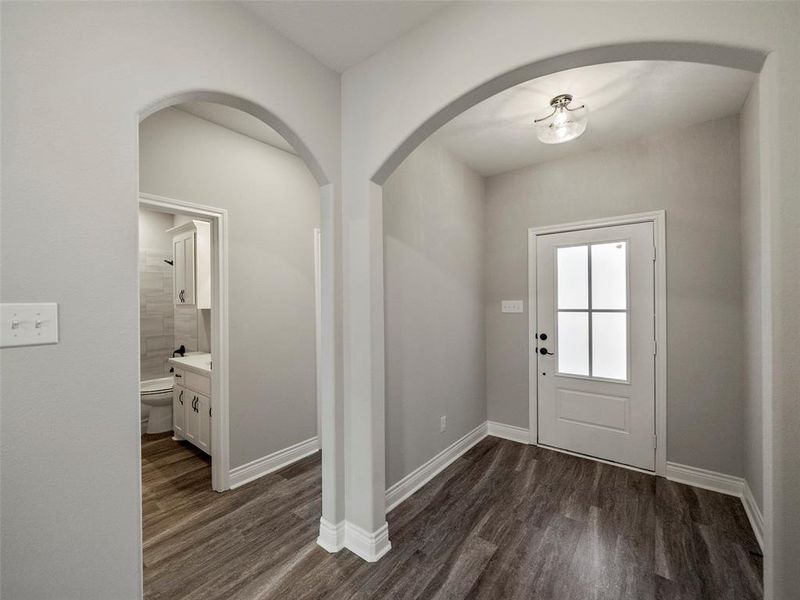 Foyer with dark wood-style floors and arched walkways Foyer with dark wood-style floors and arched walkways