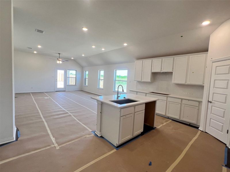 Kitchen featuring white cabinetry, recessed lighting, a kitchen island with sink, lofted ceiling, and a ceiling fan