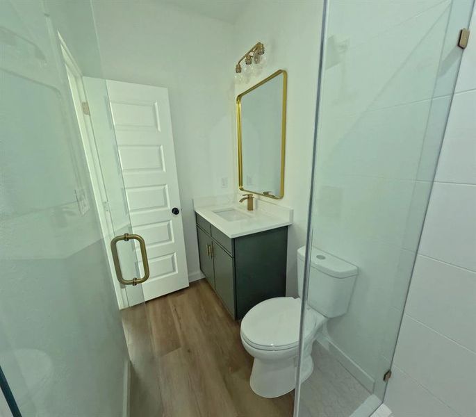 Bathroom with light wood-type flooring, vanity, and a shower stall Bathroom with light wood-type flooring, vanity, and a shower stall