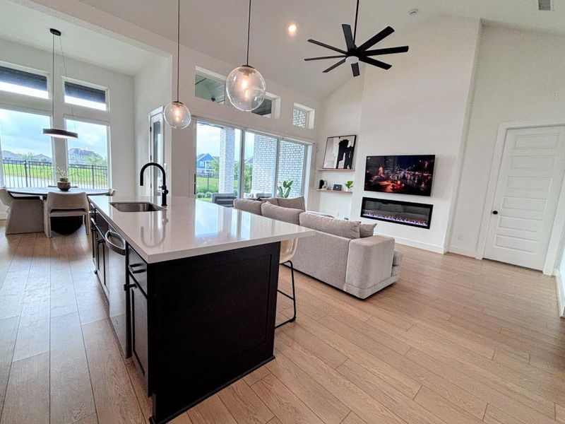 The modern living space features an open concept with large windows, a sleek kitchen island, and a cozy living area.