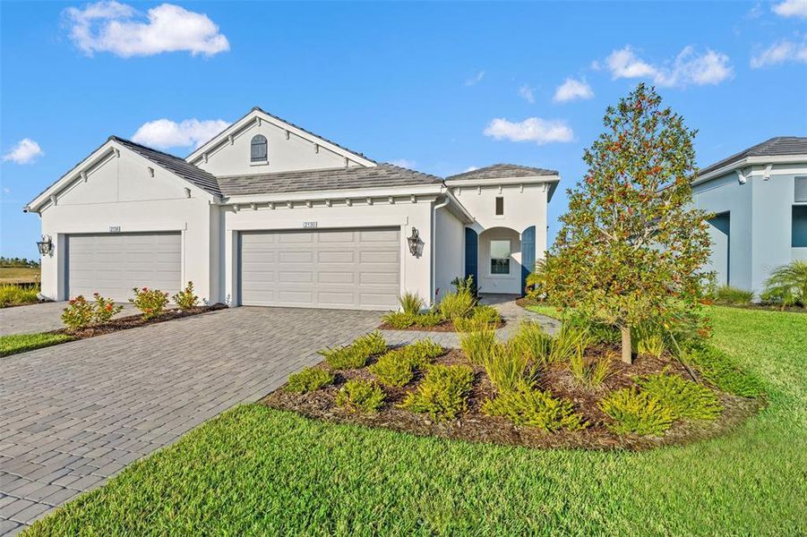 Front exterior of a new home in Palm Grove, Lakewood Ranch, FL, highlighting curb appeal (Image 24). Front exterior of a new home in Palm Grove, Lakewood Ranch, FL, highlighting curb appeal (Image 24).