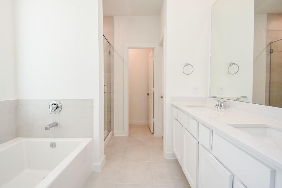 Appealing white walls and cabinetry are yours to explore in your primary ensuite bath, with plenty of leg room for your own rhythms.