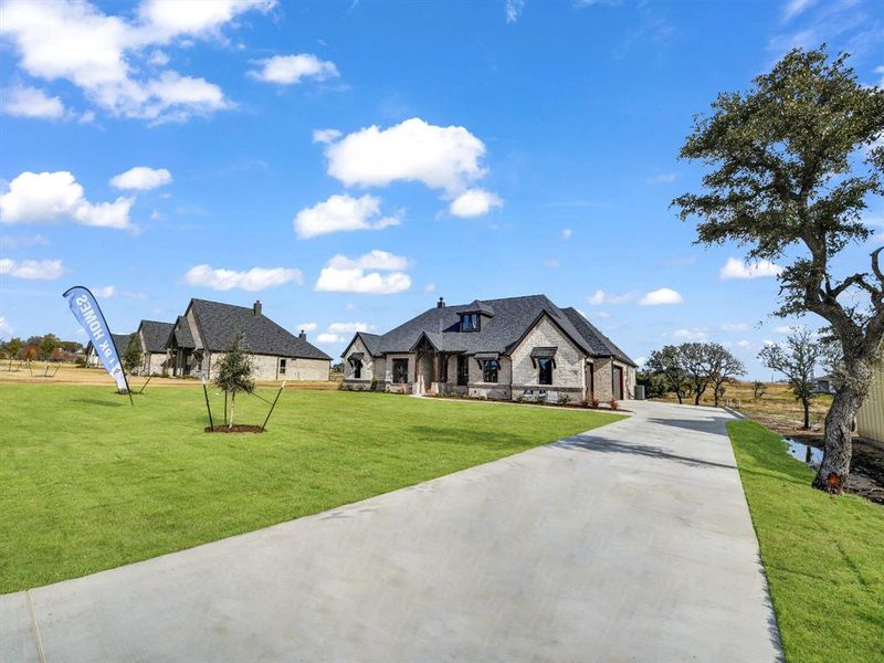 French country inspired facade featuring a front yard