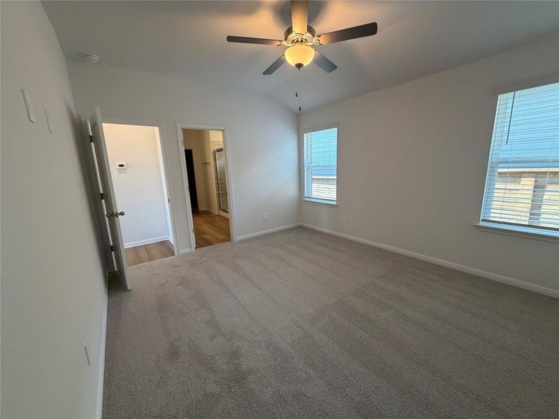 Unfurnished bedroom with carpet, a ceiling fan, and connected bathroom