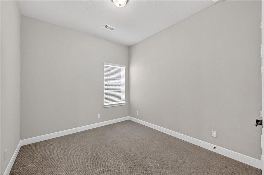 Neutral toned room featuring light gray walls, white baseboards, and textured carpeting Neutral toned room featuring light gray walls, white baseboards, and textured carpeting