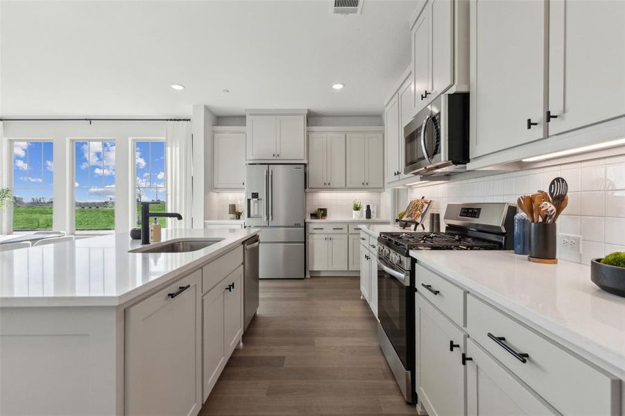 A stylish backsplash, stainless appliances, pot & pan drawers and so much more can be found in this over the top kitchen!