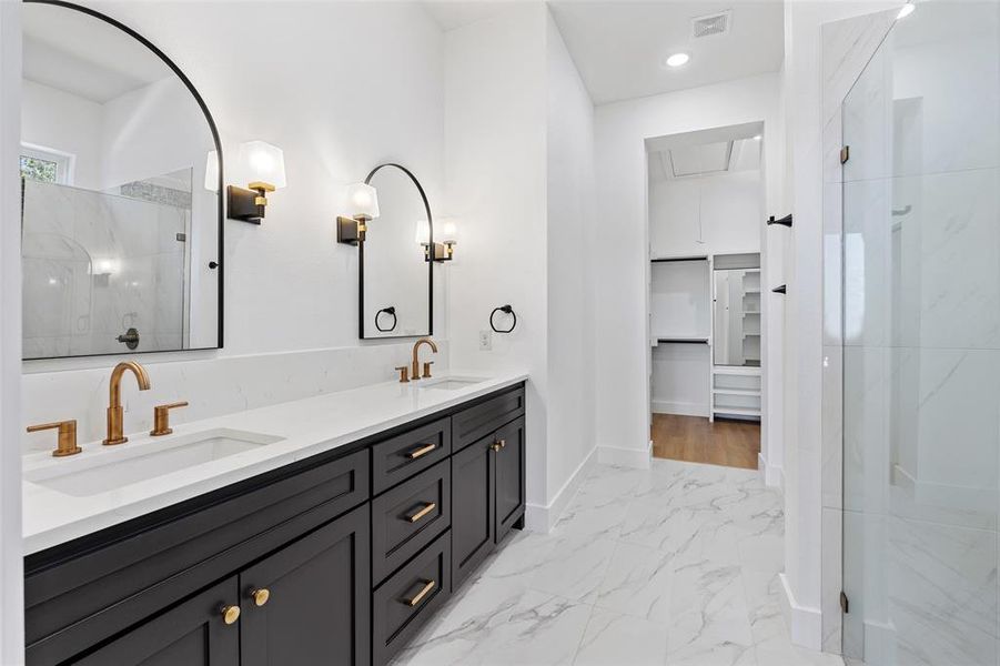 Bathroom featuring a shower with door and vanity