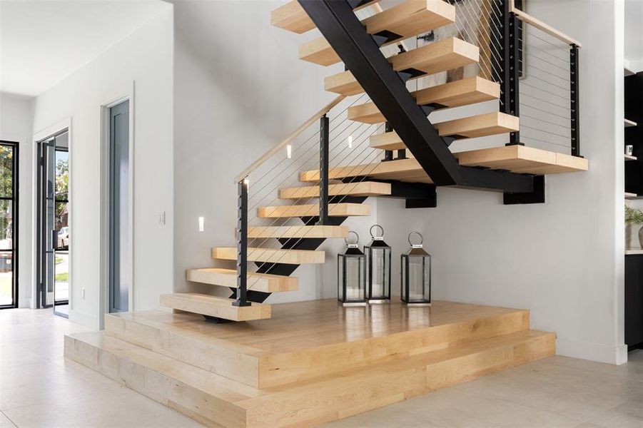 Staircase with tile patterned floors and a high ceiling