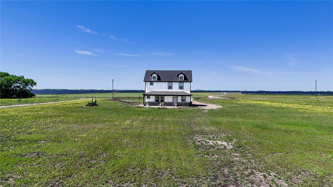 Two-story home with white siding and a dark roof