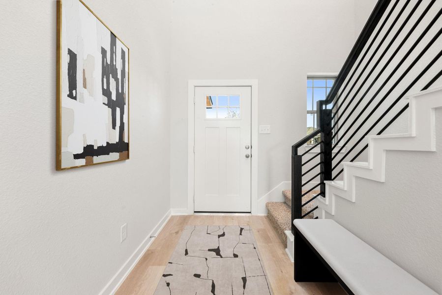 A bright and welcoming entryway featuring clean lines, modern railing details, and natural light that sets the tone for the home’s contemporary style. A bright and welcoming entryway featuring clean lines, modern railing details, and natural light that sets the tone for the home’s contemporary style.