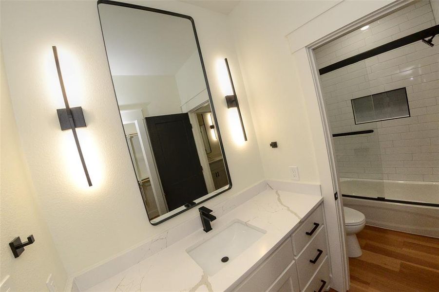 Full bathroom with vanity, washtub / shower combination, and wood finished floors