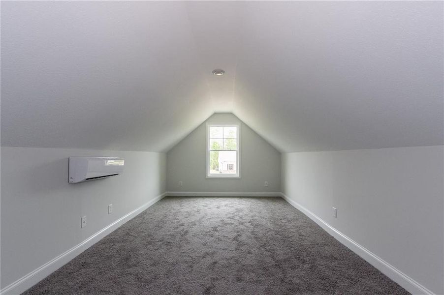 Bonus room featuring lofted ceiling, a wall mounted AC, and carpet floors