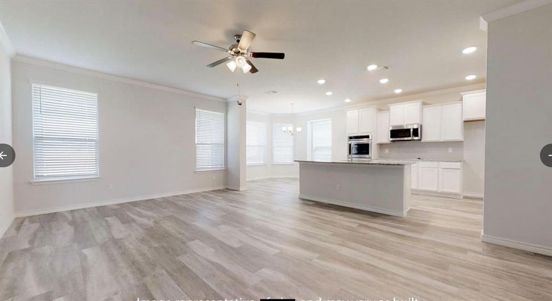 Kitchen featuring appliances with stainless steel finishes, a ceiling fan, crown molding, white cabinetry, and a chandelier