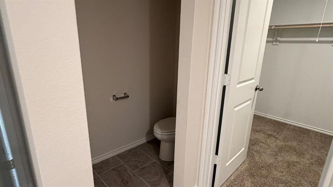 Bathroom with toilet and dark tile patterned floors