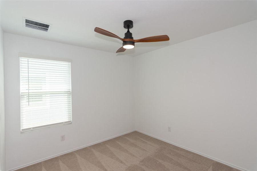 Interior room featuring neutral wall paint, a ceiling fan with wood-finish blades, and carpet flooring