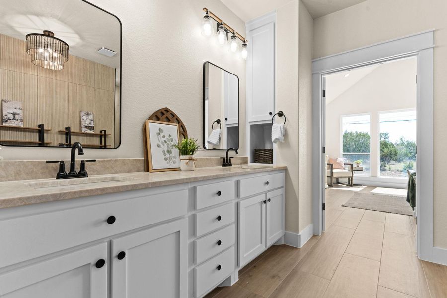 Bathroom featuring double vanity and baseboards Bathroom featuring double vanity and baseboards