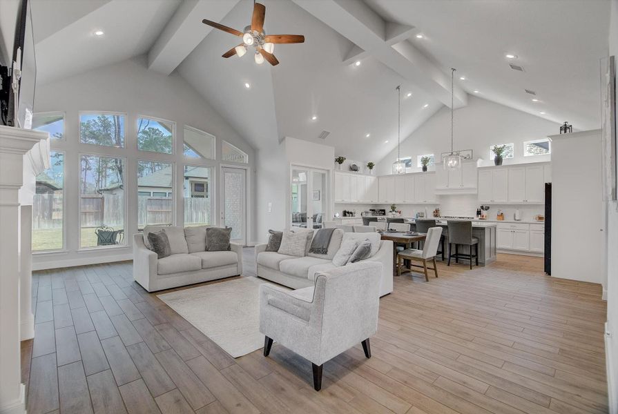 At the end of the foyer, you’re welcomed into a spacious living, dining, and kitchen area highlighted by 15' ceilings, abundant recessed lighting, and striking cathedral-style architectural lines that make the entire space feel open, bright, and impressive.