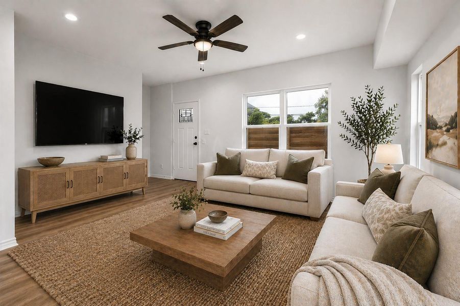 Bright and airy living room featuring an open layout with abundant natural light and warm luxury vinyl plank flooring throughout. Large windows enhance the sense of space and provide a strong connection to the outdoors. Clean lines, neutral tones, and a modern farmhouse aesthetic create a versatile backdrop that appeals to a wide range of styles. The room offers excellent flow for both everyday living and entertaining, making it a welcoming and functional centerpiece of the home. (Photo virtually staged)