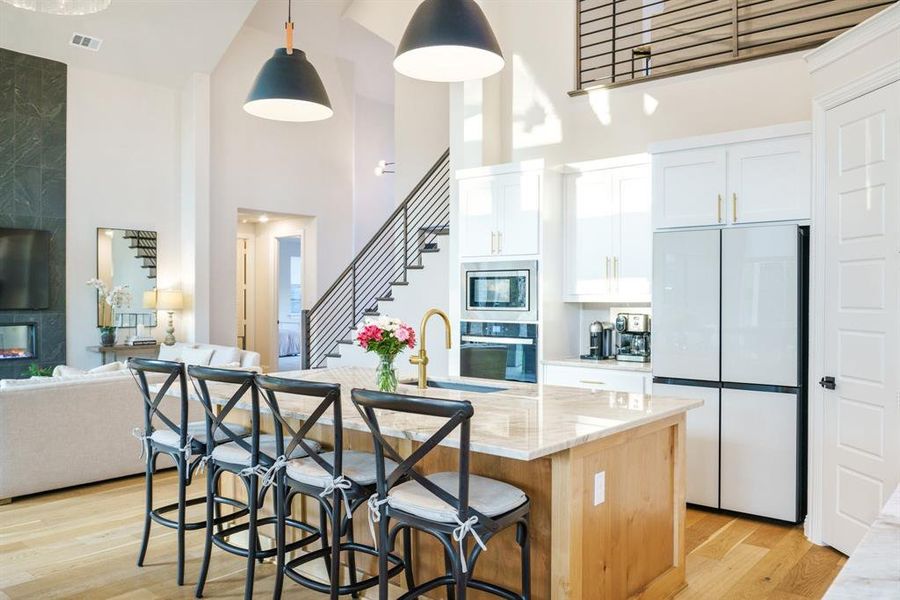 Seamless Sophistication - This alternate angle captures the elegant connection between the kitchen and living area, highlighting the custom railing, dramatic ceiling height, and smart use of vertical space. Seamless Sophistication - This alternate angle captures the elegant connection between the kitchen and living area, highlighting the custom railing, dramatic ceiling height, and smart use of vertical space.