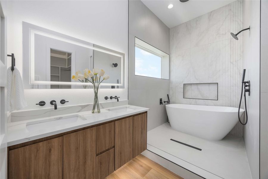 A luxurious, spa-like primary bath featuring an elegantly detailed shower wall.