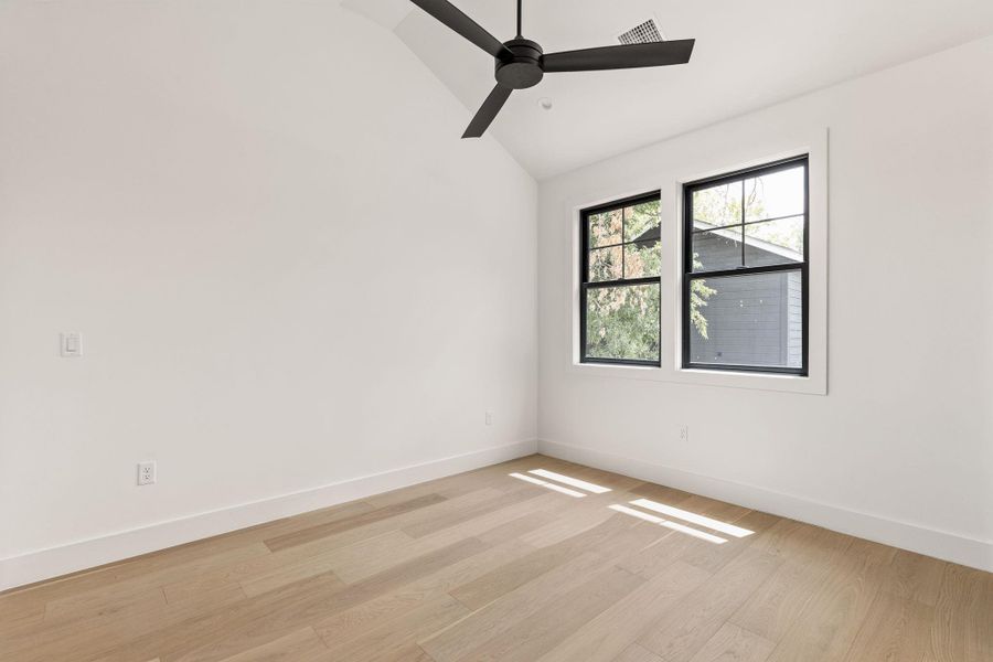 Unfurnished room featuring lofted ceiling, light wood-type flooring, and ceiling fan Unfurnished room featuring lofted ceiling, light wood-type flooring, and ceiling fan