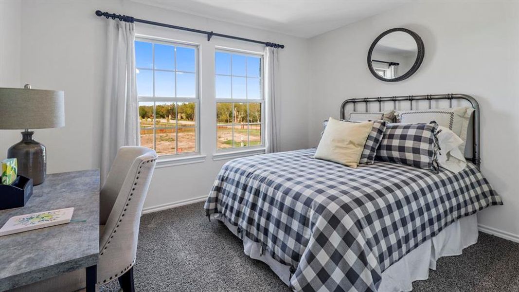 Bedroom featuring dark colored carpet and baseboards