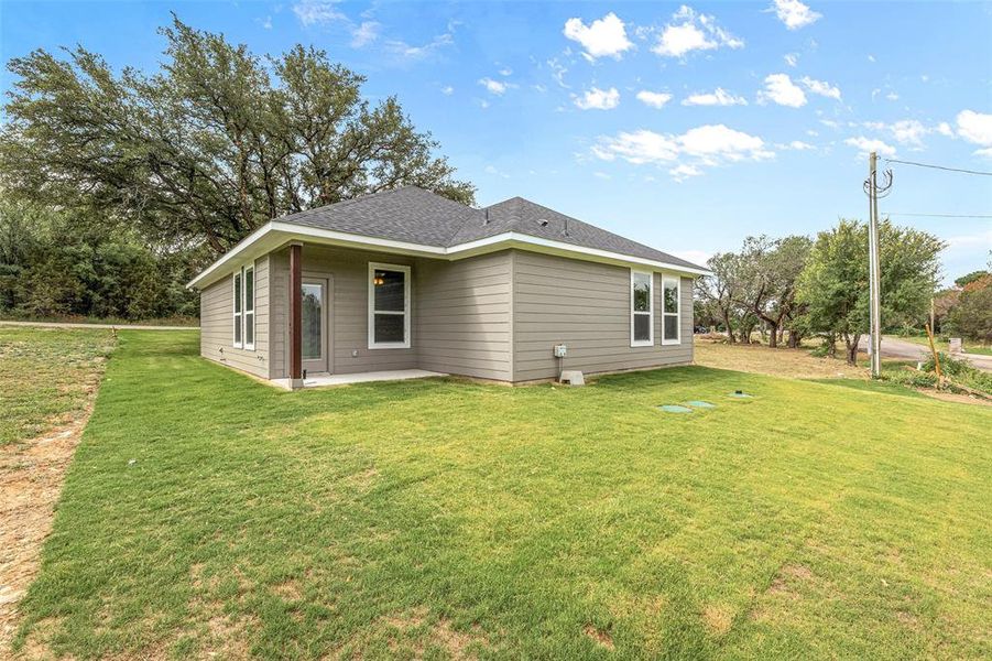 Rear view of house featuring a yard