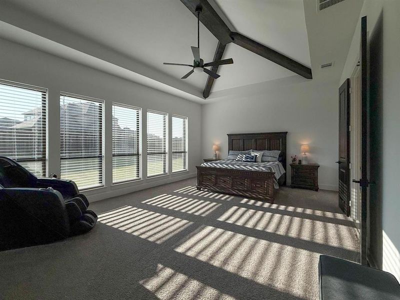 Bedroom with beam ceiling, carpet, and ceiling fan Bedroom with beam ceiling, carpet, and ceiling fan