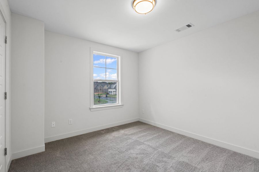 Spare room featuring carpet floors and baseboards