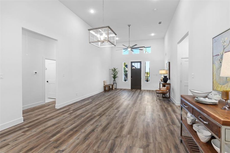 Entryway featuring a towering ceiling, ceiling fan, and dark wood-type flooring