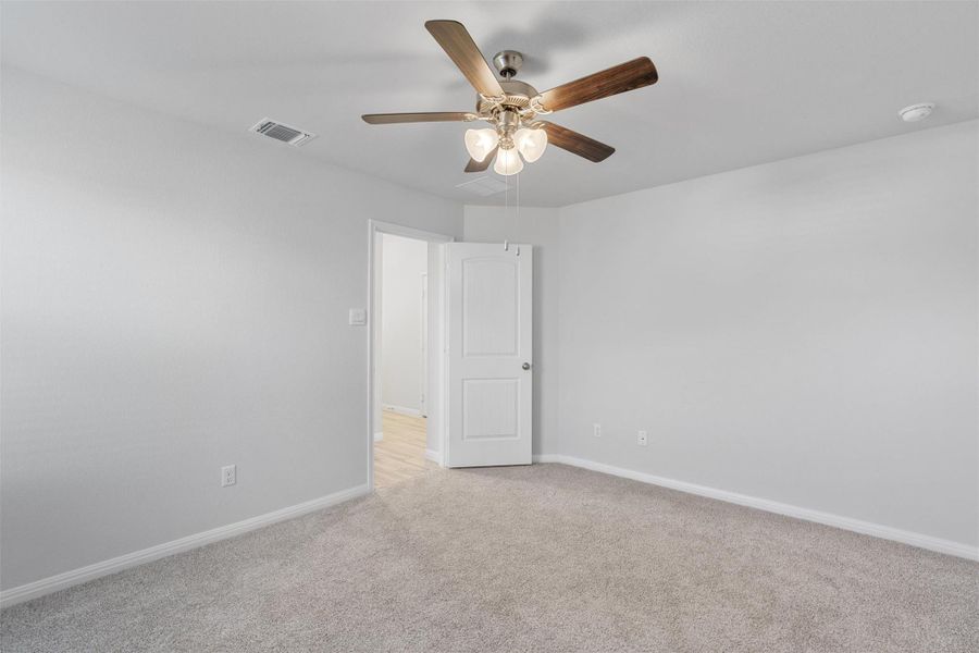 Empty room with light carpet and ceiling fan