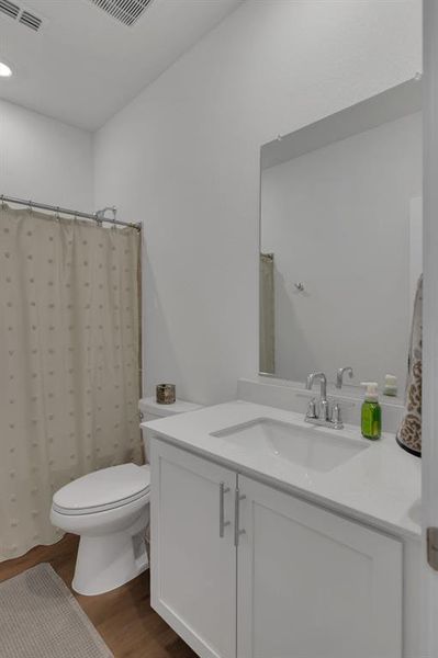 Full bath with vanity, wood finished floors, a shower with curtain, and recessed lighting