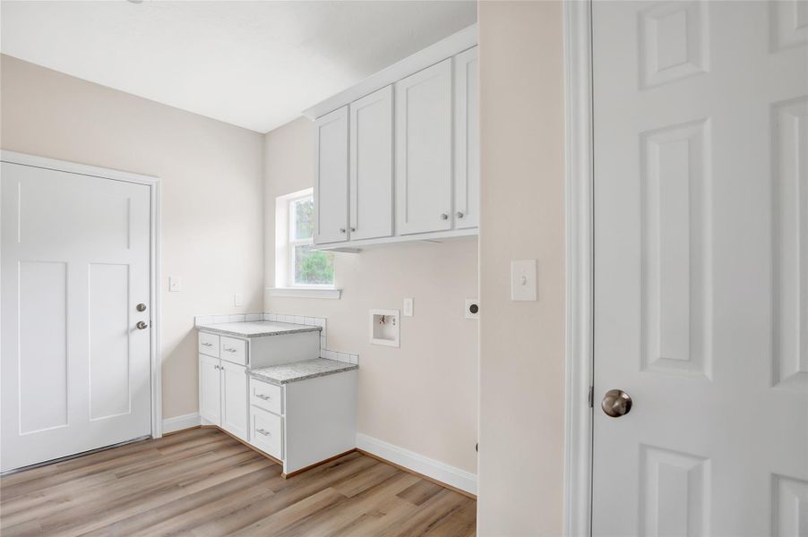 Additional storage plus a place to fold your laundry. Door on the left leads to the garage. Door on the right is more storage.