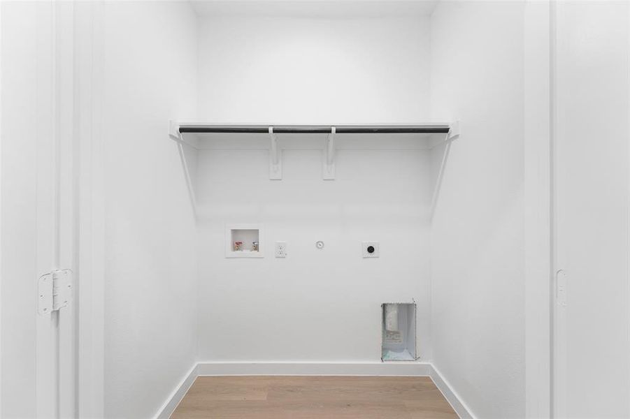 Dedicated laundry area with light wood-finish flooring