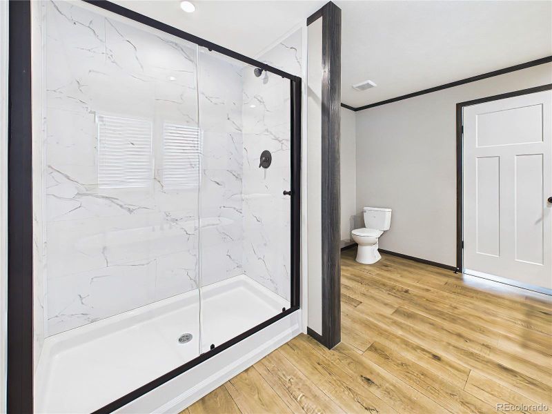 Primary Bathroom (Shower) – Walk-in shower with contemporary tile surround and glass enclosure, offering a clean and modern design.