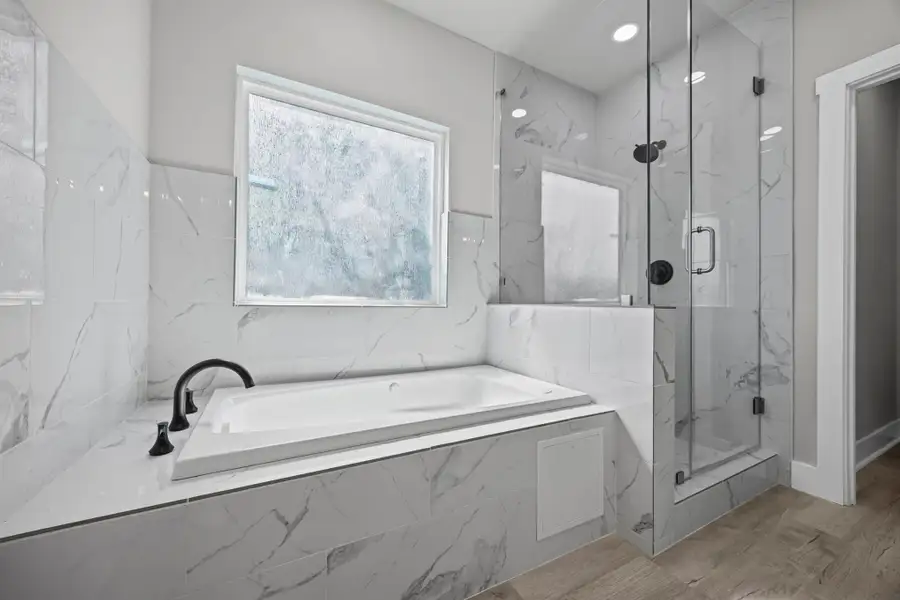 Full bath with a marble finish shower, a bath, wood finished floors, and recessed lighting Full bath with a marble finish shower, a bath, wood finished floors, and recessed lighting